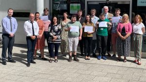 Group photo of young people with certificates along with tutors and support staff. They are stood outside the Youth Hub building in Exeter